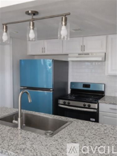 A kitchen with a blue refrigerator and stove.