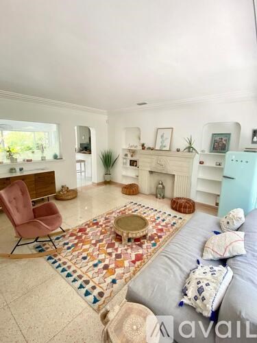 A living room with a grey couch and a multicolored mosaic table in the middle.