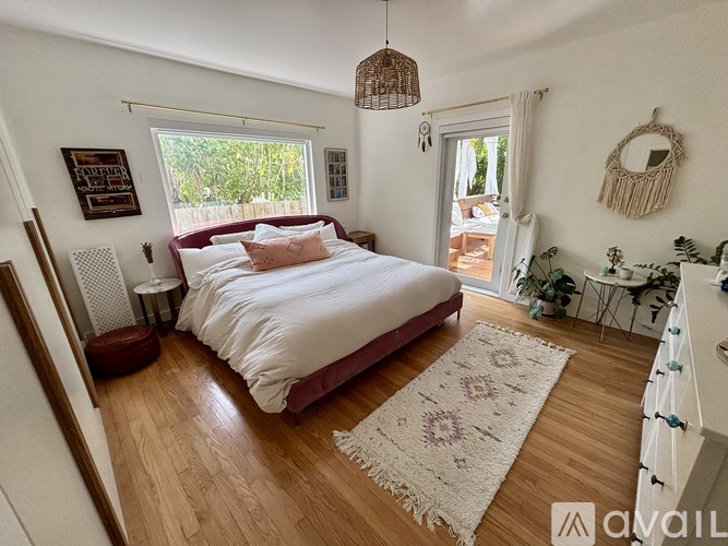 A bedroom with a large bed and a wooden floor.