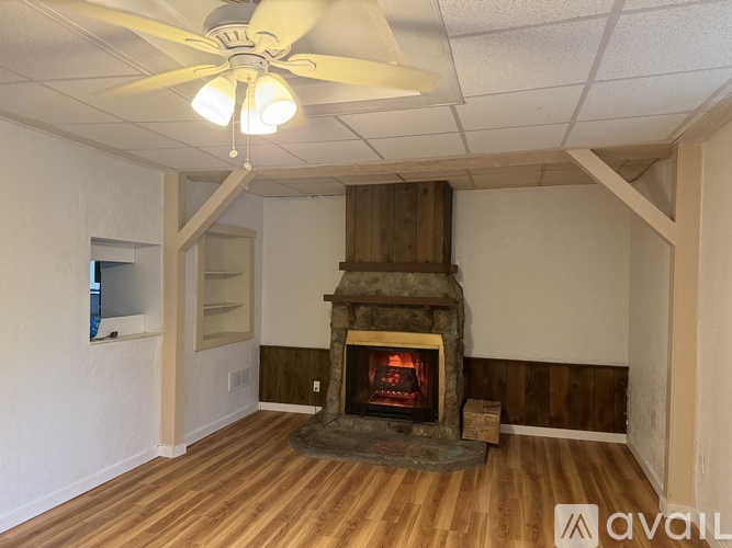 A room with a fireplace and a ceiling fan.