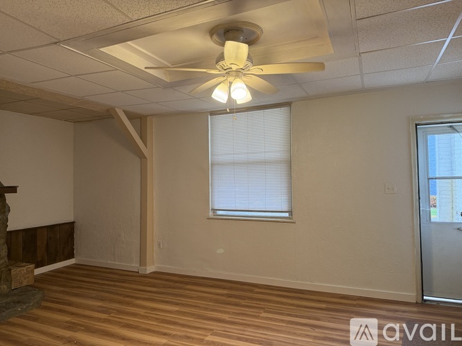 A room with a ceiling fan and wooden flooring.