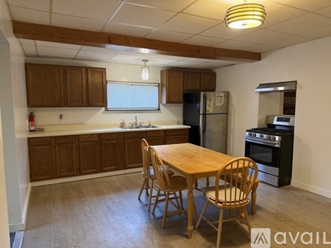 A kitchen with wooden cabinets and a table with chairs.