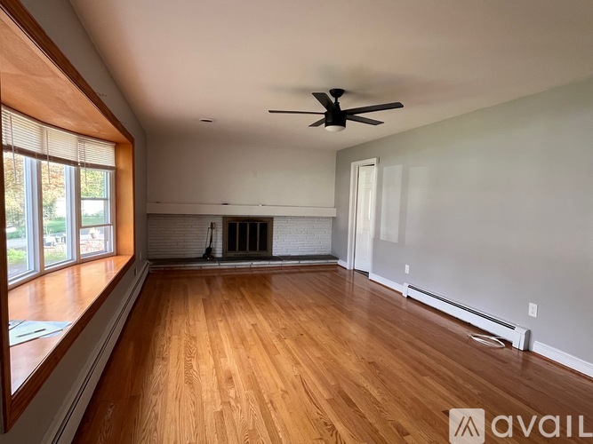 A room with wooden floors and a ceiling fan.