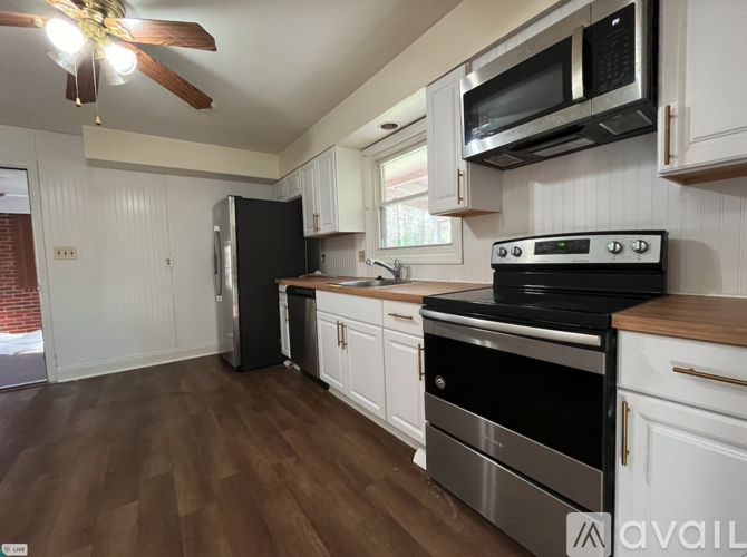 A kitchen with white cabinets and a black stove top oven.