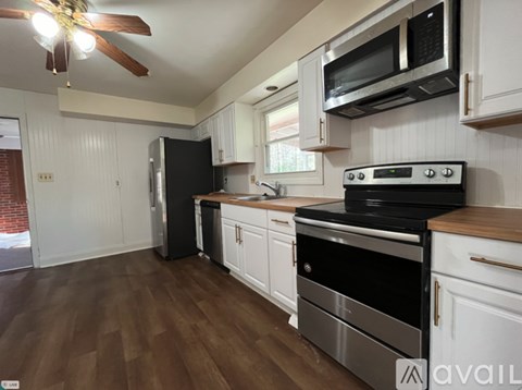 A kitchen with white cabinets and a black stove top oven.