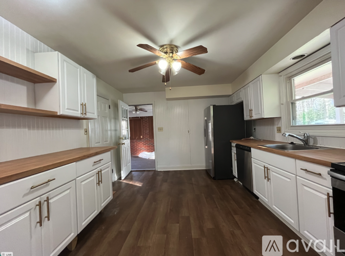 A kitchen with white cabinets and a wooden floor.