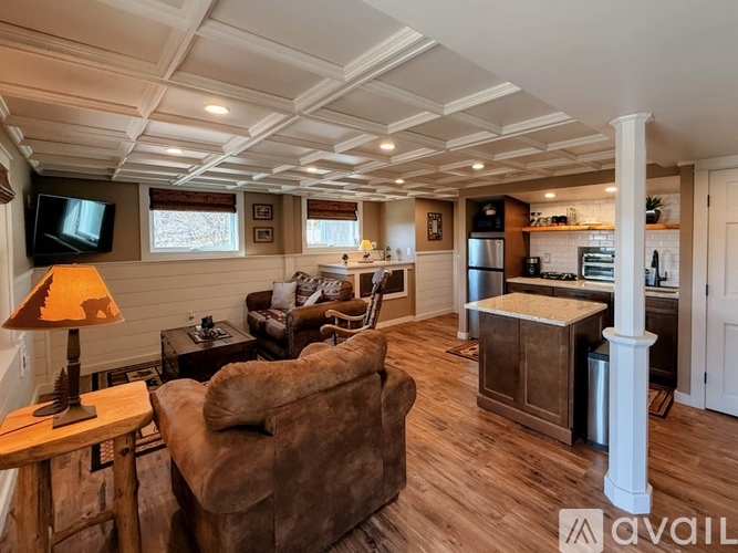 A living room with a brown couch and a wooden floor.