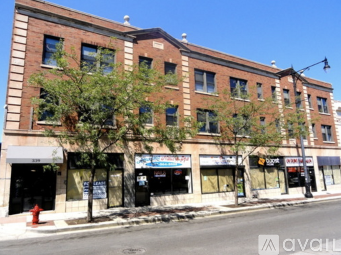 A street view of a multi-story building with storefronts on the ground floor.
