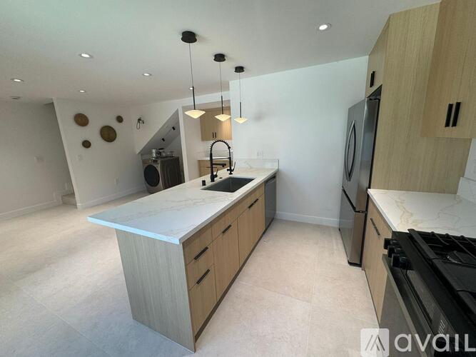 A modern kitchen with wooden cabinets and a large island.