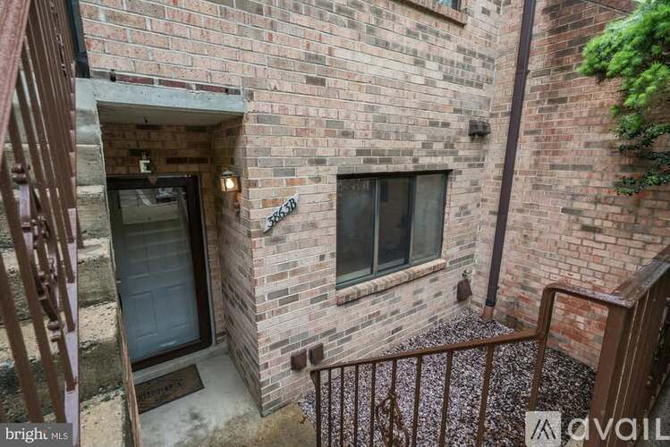 A balcony with a brick wall and a metal railing.