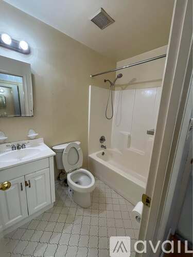 A bathroom with a toilet, sink, and bathtub.
