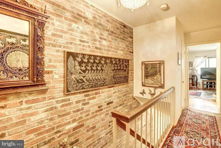A hallway with a brick wall and a chandelier.