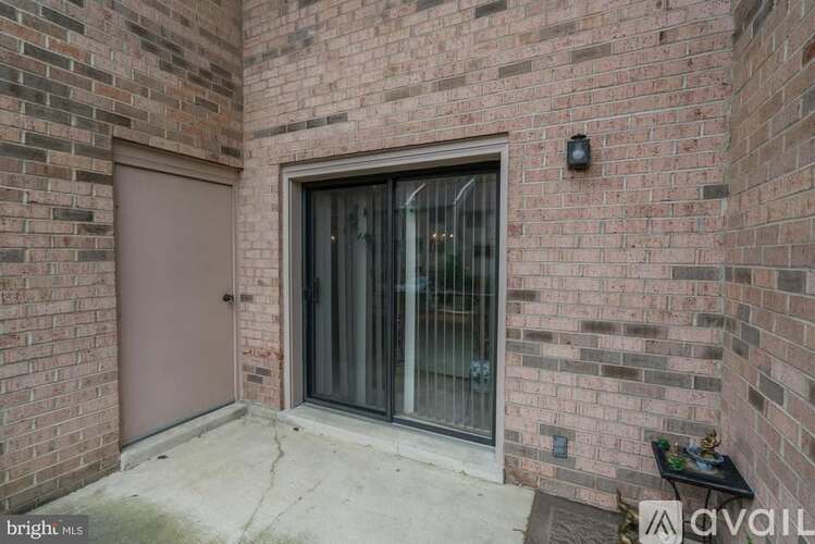 A brick wall with a glass door and a brown door.
