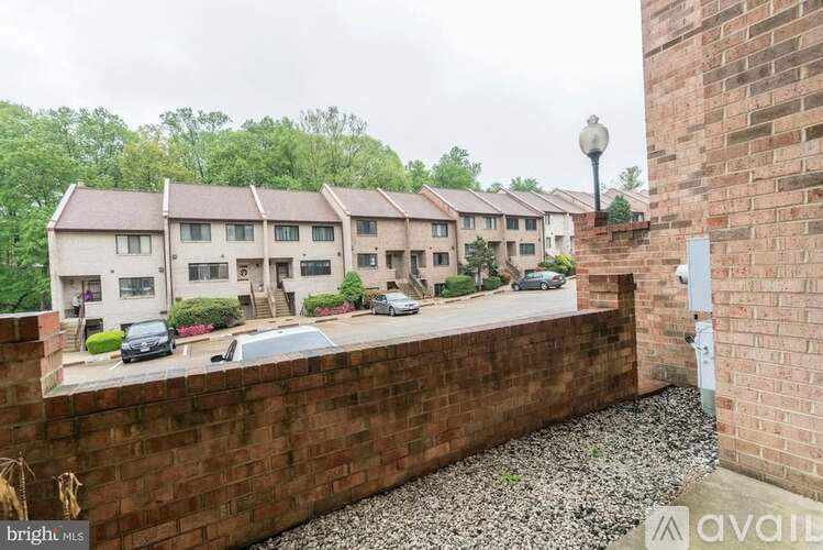 A brick wall with a view of apartment buildings in the background.