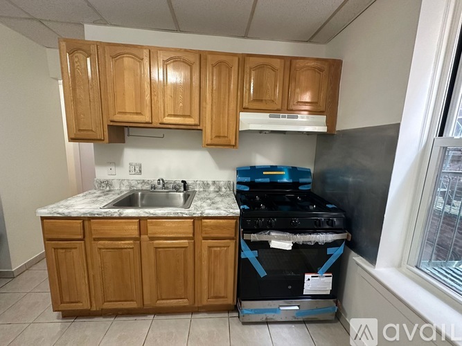A kitchen with wooden cabinets and a marble countertop.