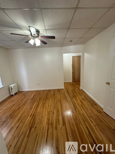 A room with wooden floors and a ceiling fan.