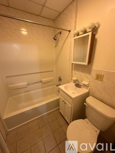 A white bathroom with a toilet, sink, and bathtub.