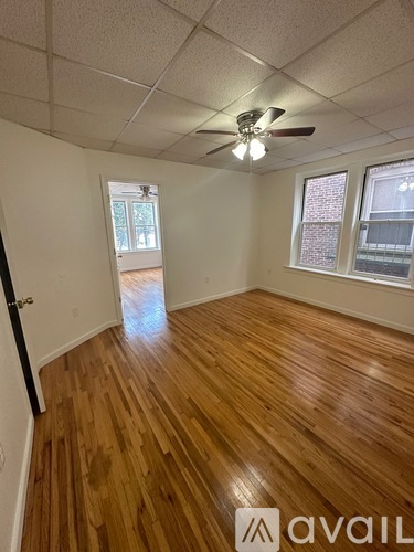 A room with wooden flooring and a ceiling fan.