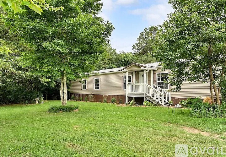 A house with a porch surrounded by trees.