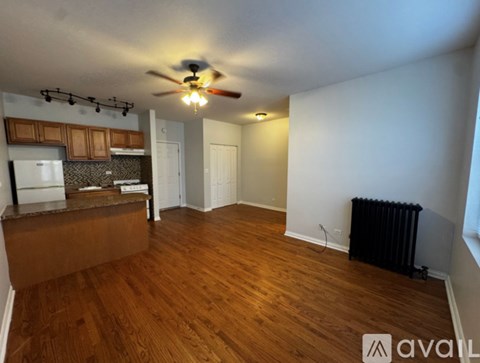 A room with wooden floors and a ceiling fan.