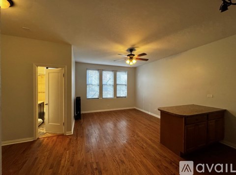 A room with wooden floors and a ceiling fan.