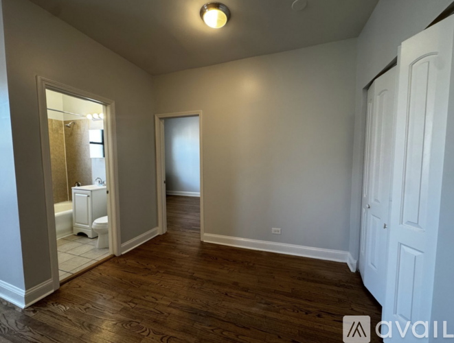 A bathroom with a toilet, sink, and mirror.
