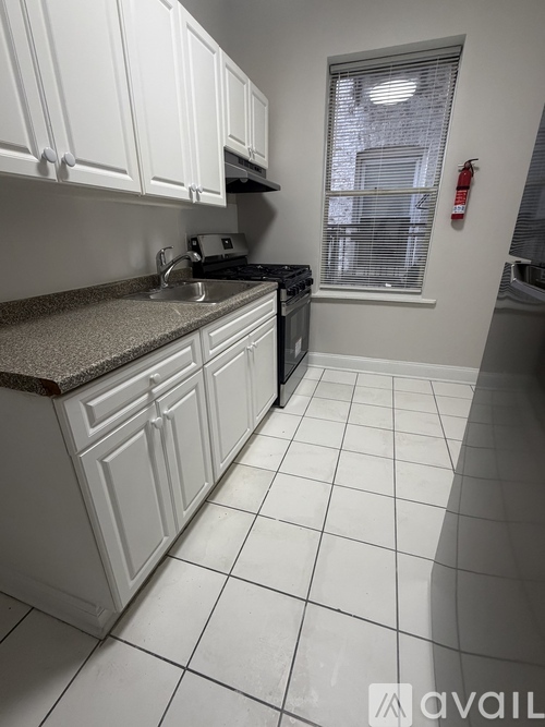 A kitchen with white cabinets and a granite countertop.