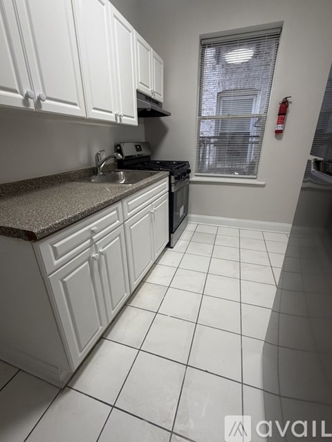 A kitchen with white cabinets and a granite countertop.
