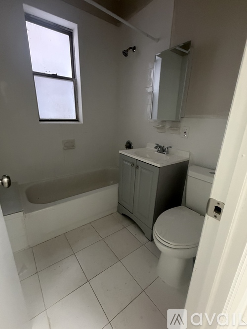 A bathroom with a toilet, sink, and bathtub.