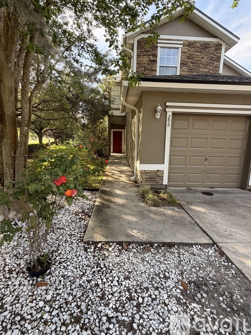 A house with a garage and a driveway with a gravel path.