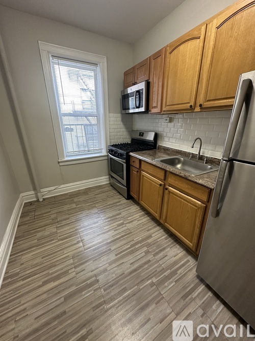 A kitchen with wooden cabinets and a refrigerator.