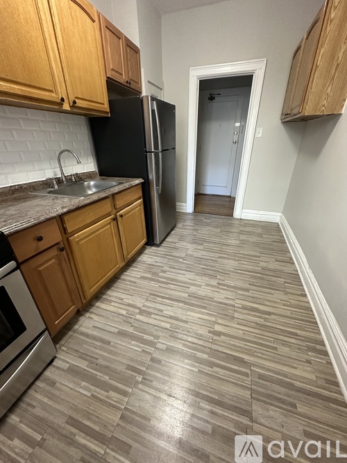 A kitchen with wooden cabinets and a black refrigerator.