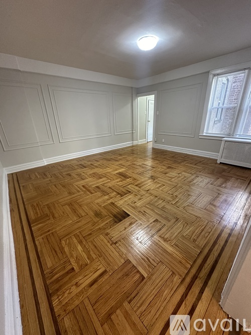 A room with wooden flooring and white walls.