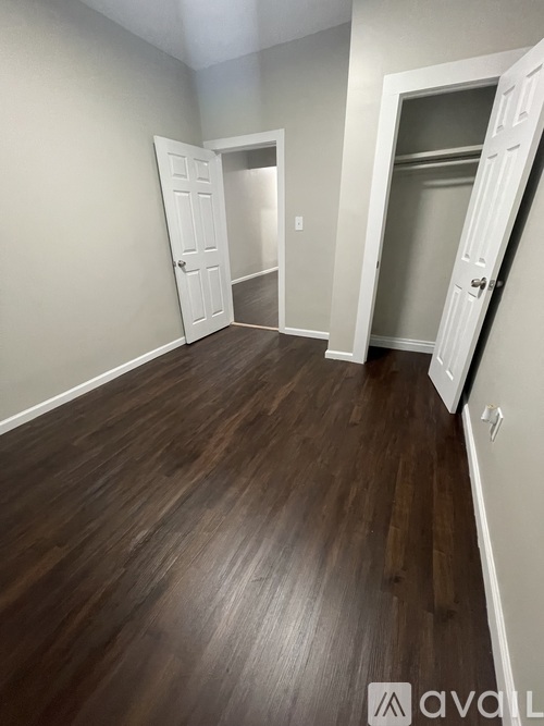 A room with wooden floors and white doors.