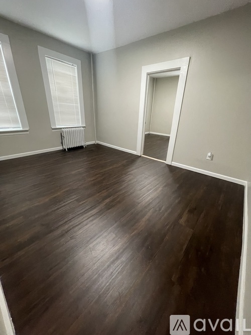 A room with wooden flooring and a white door.