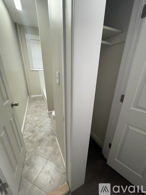 A hallway with white doors and a tiled floor.