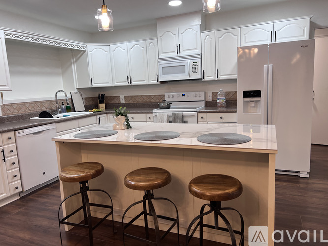 A kitchen with white cabinets and a white refrigerator.