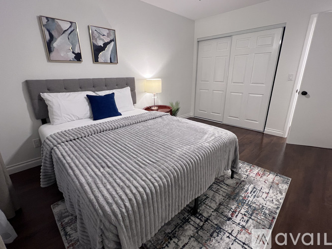 A bedroom with a large bed and two framed pictures on the wall.