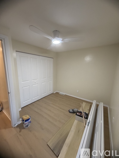 A room with a ceiling fan and a white door.