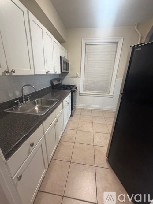 A kitchen with black appliances and white cabinets.