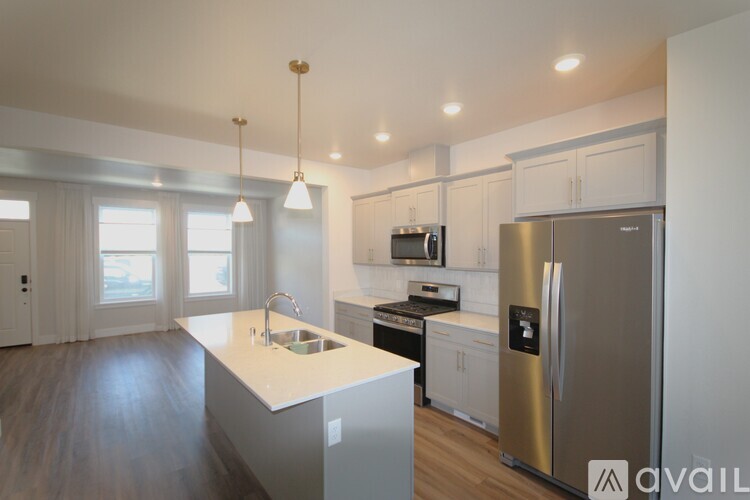 A modern kitchen with a white island and stainless steel appliances.