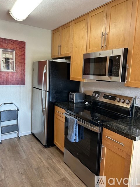 A kitchen with wooden cabinets and black appliances.