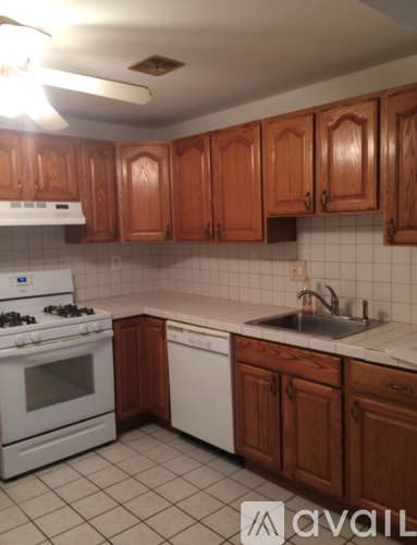 A kitchen with white appliances and brown cabinets.
