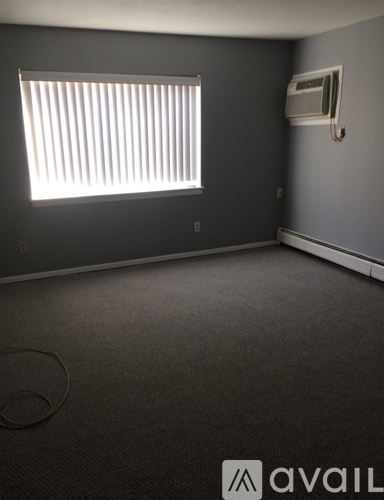 A room with a window and an air conditioner unit on the wall.