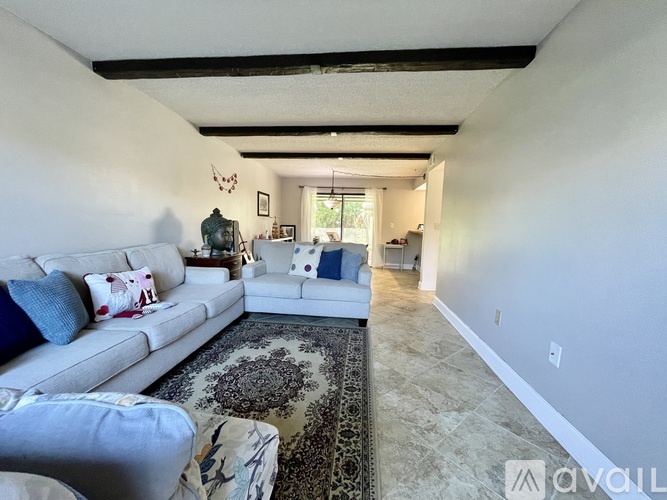 A living room with a white couch and a rug.