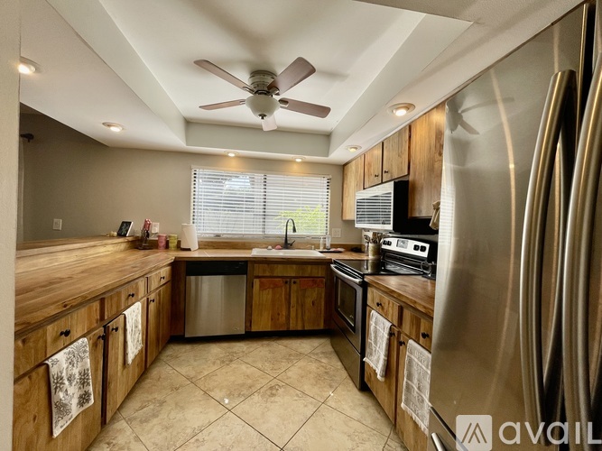 A kitchen with wooden cabinets and a stainless steel refrigerator.