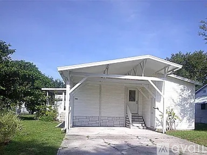 A white house with a covered porch and a white garage door.
