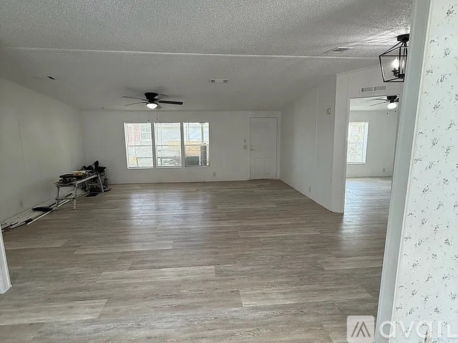 A spacious room with a ceiling fan and lighting fixture.