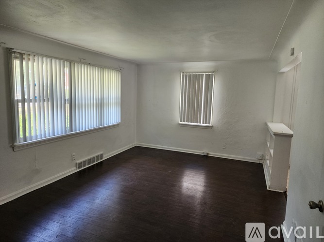 A room with a window and a door is available for rent.
