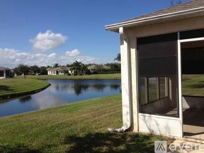 A house with a view of a lake and a cloudy sky.